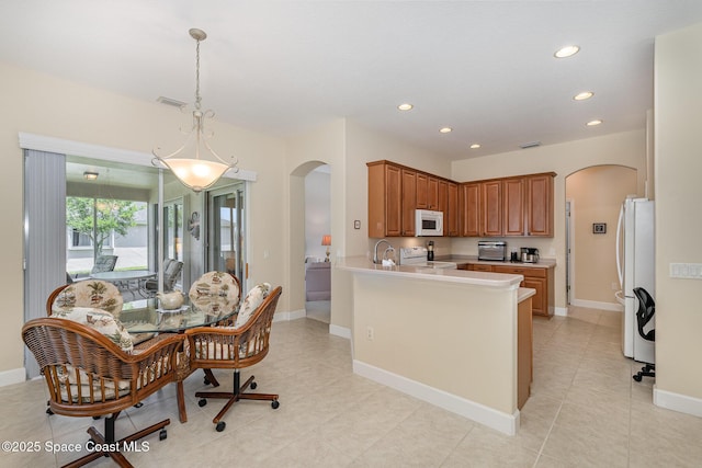3156 Quint Dr, Melbourne, FL 32940 - kitchen with arched walkways, white appliances, recessed lighting, a peninsula, and light countertops