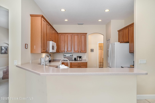 3156 Quint Dr, Melbourne, FL 32940 - kitchen featuring white appliances, recessed lighting, a peninsula, arched walkways, and light countertops