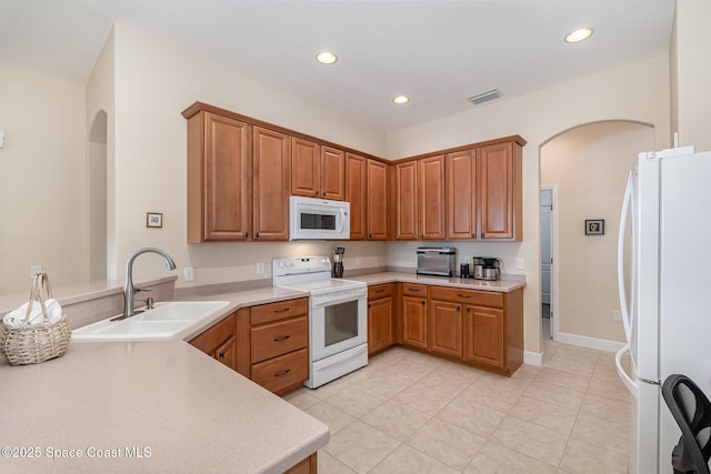 3156 Quint Dr, Melbourne, FL 32940 - kitchen featuring white appliances, a sink, arched walkways, recessed lighting, and light tile patterned floors