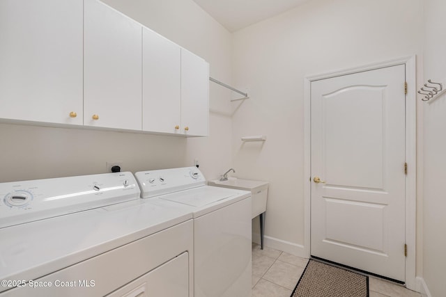 3156 Quint Dr, Melbourne, FL 32940 - laundry room featuring separate washer and dryer, cabinet space, light tile patterned floors, and baseboards