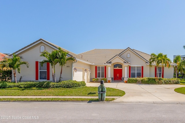 603 Manatee Bay Dr, Cape Canaveral, FL 32920 - single story home with driveway, a garage, stucco siding, and a tile roof