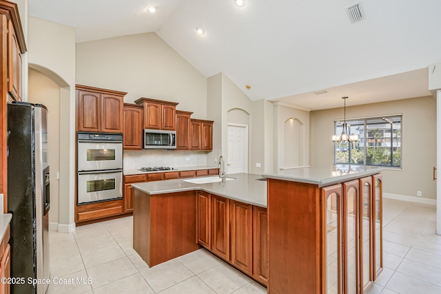 603 Manatee Bay Dr, Cape Canaveral, FL 32920 - kitchen with stainless steel appliances, a sink, light tile patterned floors, a chandelier, and high vaulted ceiling