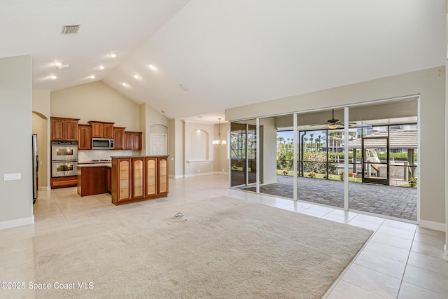 603 Manatee Bay Dr, Cape Canaveral, FL 32920 - unfurnished living room featuring light tile patterned floors, a ceiling fan, arched walkways, high vaulted ceiling, and baseboards