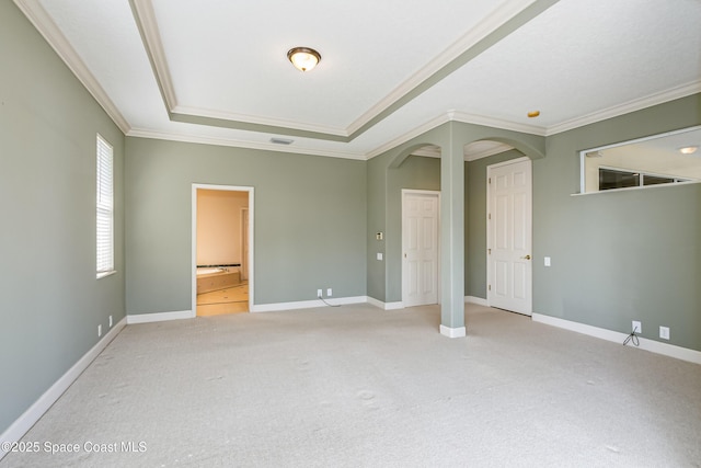 603 Manatee Bay Dr, Cape Canaveral, FL 32920 - unfurnished bedroom featuring light carpet, crown molding, arched walkways, a tray ceiling, and baseboards