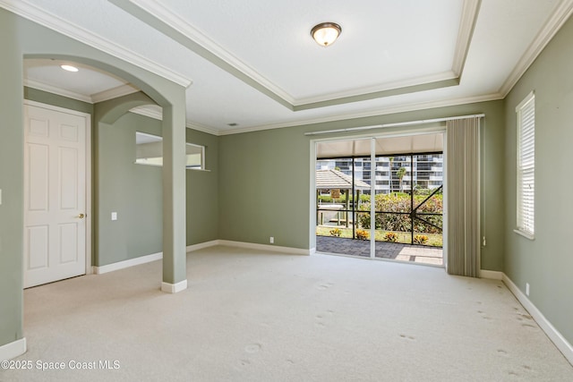 603 Manatee Bay Dr, Cape Canaveral, FL 32920 - carpeted empty room featuring crown molding, arched walkways, baseboards, and a raised ceiling
