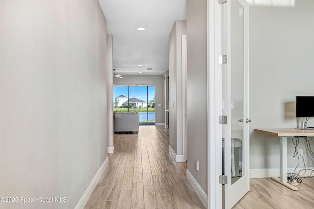 hallway featuring baseboards, wood finished floors, and recessed lighting