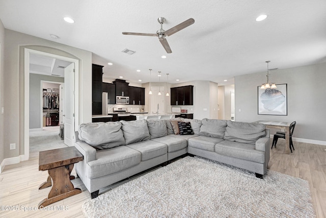 living room with light wood finished floors, baseboards, recessed lighting, and ceiling fan