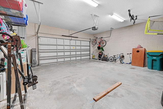 garage with concrete block wall and a garage door opener
