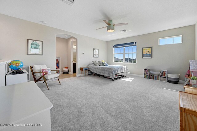 bedroom featuring arched walkways, carpet floors, visible vents, and a ceiling fan