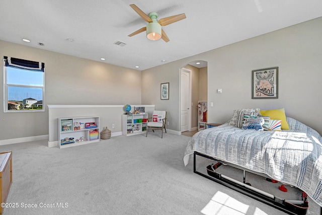 bedroom featuring a ceiling fan, arched walkways, baseboards, carpet flooring, and visible vents