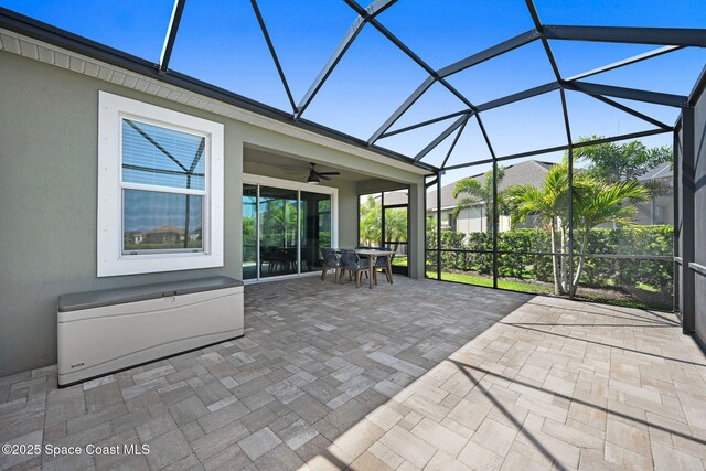 unfurnished sunroom with a ceiling fan and outdoor dining space