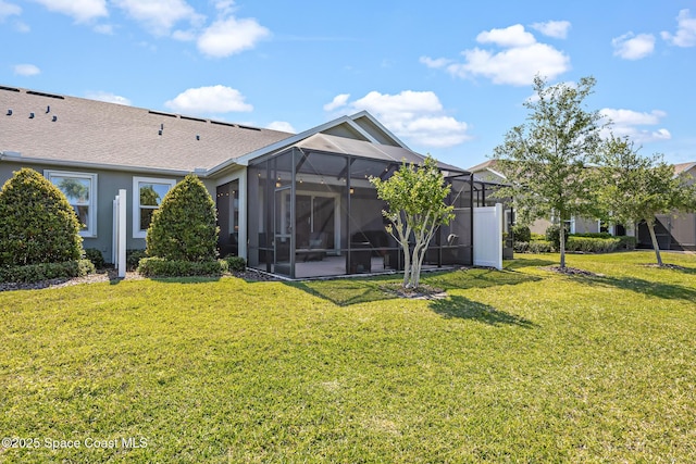 back of property featuring a yard, stucco siding, glass enclosure, and a shingled roof