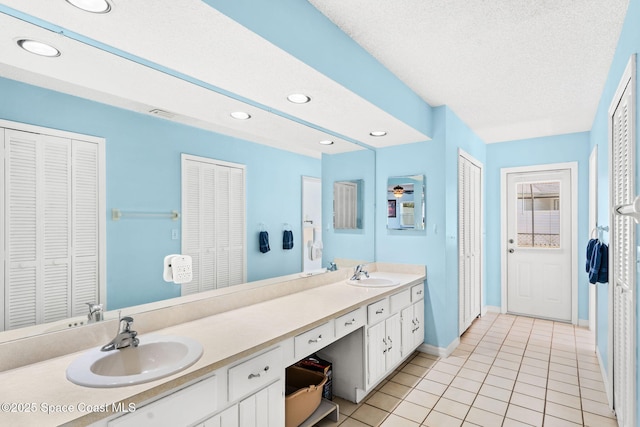 36 Mohican Way, Melbourne Beach, FL 32951 - bathroom featuring a closet, baseboards, double vanity, recessed lighting, and tile patterned flooring
