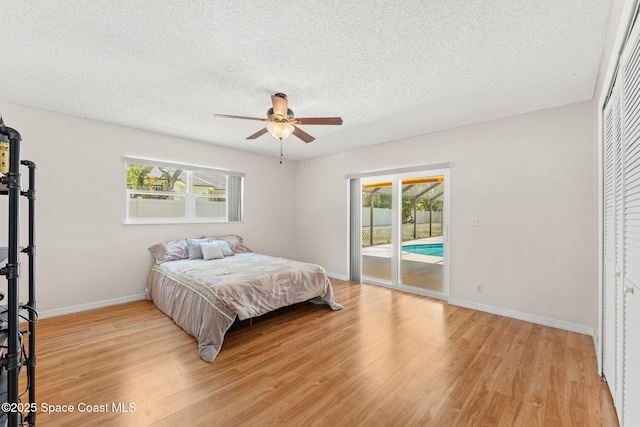 36 Mohican Way, Melbourne Beach, FL 32951 - bedroom featuring access to exterior, light wood-style floors, baseboards, a textured ceiling, and a ceiling fan