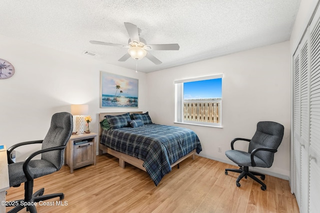 36 Mohican Way, Melbourne Beach, FL 32951 - bedroom with a desk, light wood-style floors, a textured ceiling, baseboards, and a closet