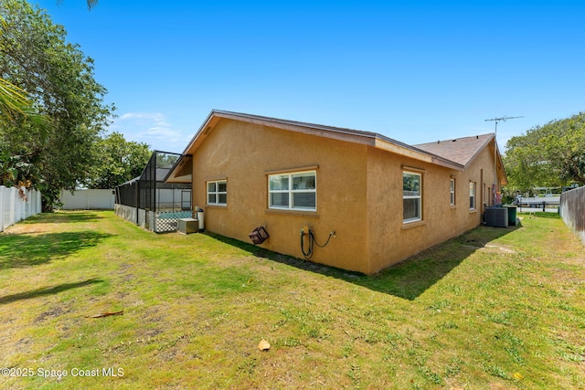 36 Mohican Way, Melbourne Beach, FL 32951 - view of home's exterior featuring stucco siding, cooling unit, and glass enclosure