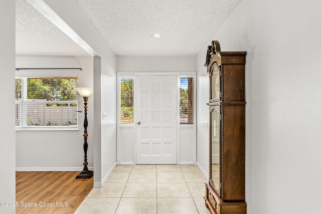 36 Mohican Way, Melbourne Beach, FL 32951 - entrance foyer featuring healthy amount of natural light, a textured ceiling, baseboards, and light wood finished floors