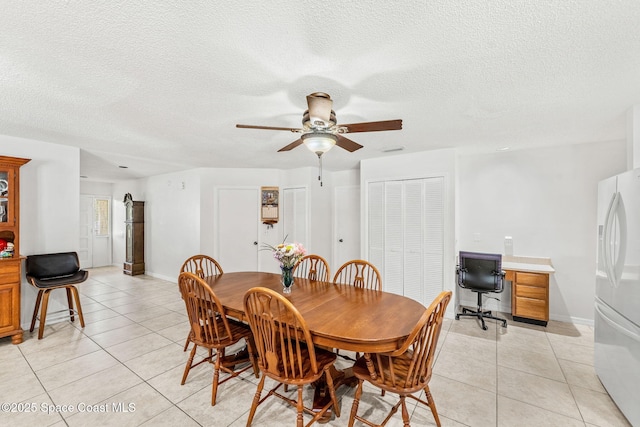 36 Mohican Way, Melbourne Beach, FL 32951 - dining room featuring light tile patterned floors, ceiling fan, a textured ceiling, a desk, and baseboards