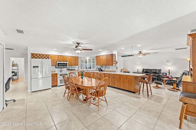 36 Mohican Way, Melbourne Beach, FL 32951 - dining area with ceiling fan, a textured ceiling, and light tile patterned floors