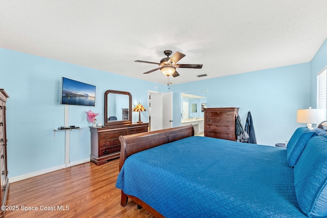 36 Mohican Way, Melbourne Beach, FL 32951 - bedroom featuring wood finished floors, baseboards, a ceiling fan, and ensuite bath