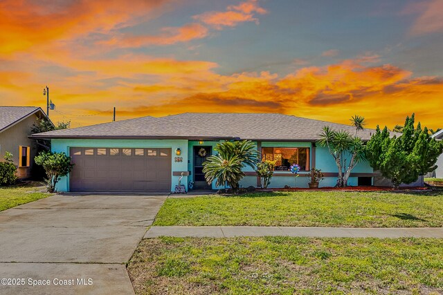 265 Sheridan Ave, Satellite Beach, FL 32937 - view of front of home featuring stucco siding, a garage, driveway, and a front lawn