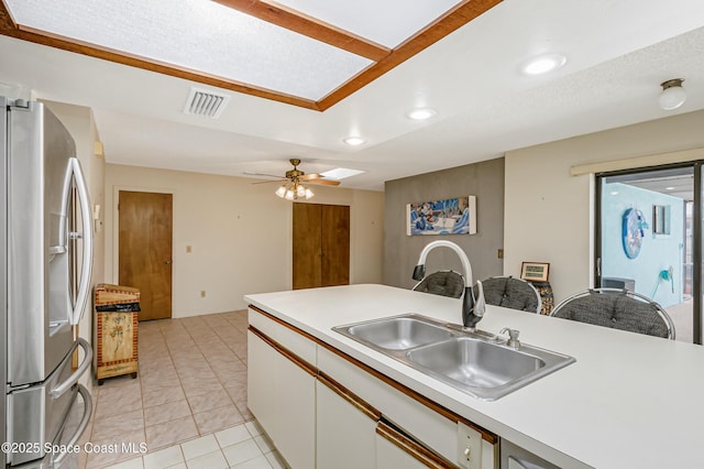265 Sheridan Ave, Satellite Beach, FL 32937 - kitchen with stainless steel refrigerator with ice dispenser, visible vents, a sink, light countertops, and white cabinetry