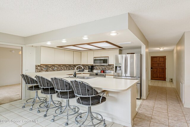 265 Sheridan Ave, Satellite Beach, FL 32937 - kitchen featuring a sink, a peninsula, a kitchen bar, and stainless steel appliances