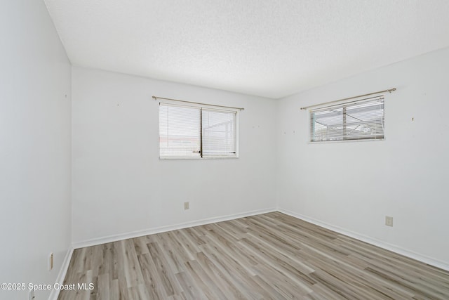 265 Sheridan Ave, Satellite Beach, FL 32937 - unfurnished room with a textured ceiling, baseboards, and light wood-style floors