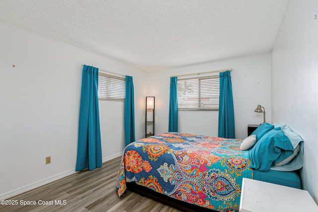 265 Sheridan Ave, Satellite Beach, FL 32937 - bedroom with baseboards, a textured ceiling, wood finished floors, and multiple windows