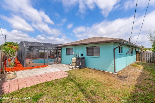 265 Sheridan Ave, Satellite Beach, FL 32937 - rear view of house with stucco siding, a fenced backyard, a fenced in pool, a patio area, and a yard