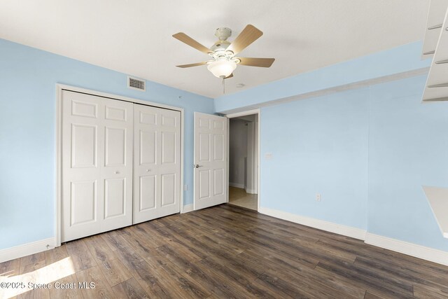 551 Casa Bella Dr Unit 501, Cape Canaveral, FL 32920 - unfurnished bedroom with baseboards, wood finished floors, a closet, and a ceiling fan