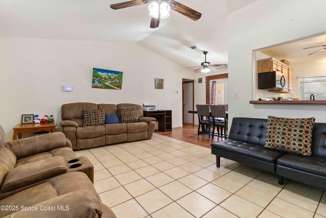 1019 Lee Ave NW, Palm Bay, FL 32907 - living room with visible vents, light tile patterned floors, a ceiling fan, and vaulted ceiling