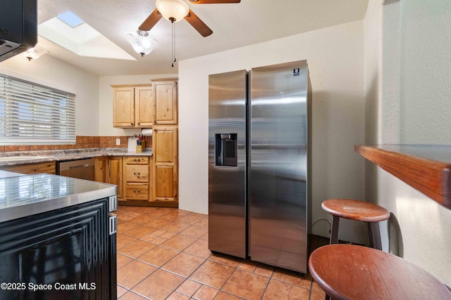 1019 Lee Ave NW, Palm Bay, FL 32907 - kitchen with light tile patterned floors, appliances with stainless steel finishes, a ceiling fan, a textured wall, and light brown cabinetry