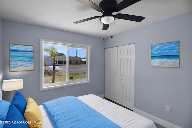 bedroom with a closet, a ceiling fan, and baseboards