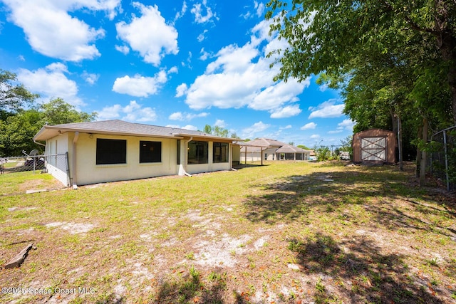 2102 E Parkton Dr, Deltona, FL 32725 - back of property featuring an outbuilding, a shed, a lawn, stucco siding, and fence