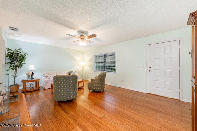 2102 E Parkton Dr, Deltona, FL 32725 - living area with light wood-type flooring, visible vents, ceiling fan, and a textured ceiling