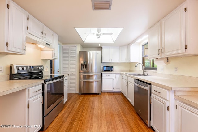 2102 E Parkton Dr, Deltona, FL 32725 - kitchen with a sink, under cabinet range hood, stainless steel appliances, visible vents, and a skylight