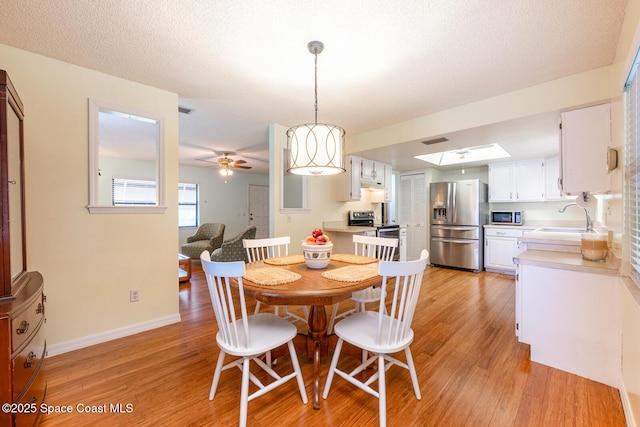 2102 E Parkton Dr, Deltona, FL 32725 - dining space featuring visible vents, light wood-type flooring, a ceiling fan, and baseboards