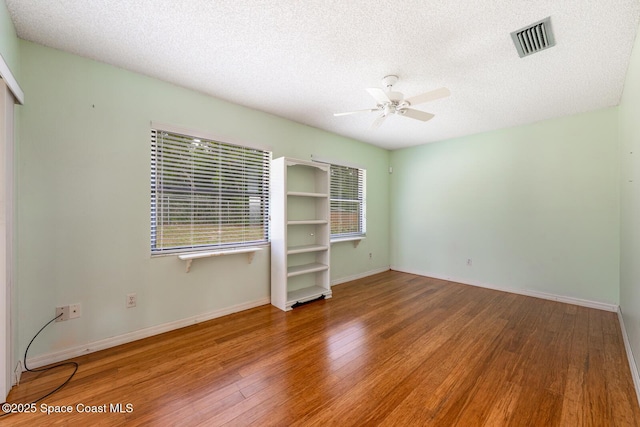 2102 E Parkton Dr, Deltona, FL 32725 - empty room with a textured ceiling, visible vents, ceiling fan, and wood finished floors