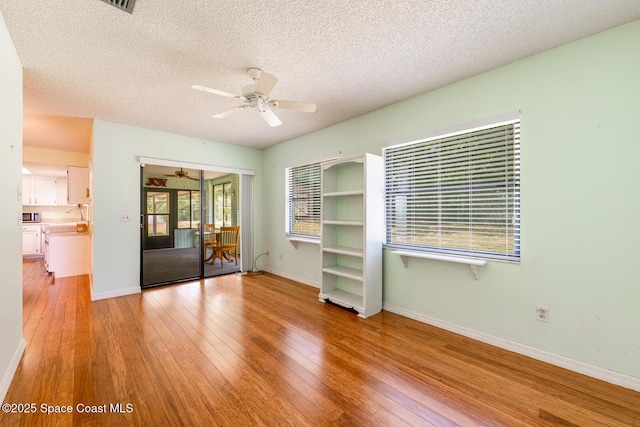 2102 E Parkton Dr, Deltona, FL 32725 - unfurnished room featuring a textured ceiling, ceiling fan, light wood finished floors, and baseboards