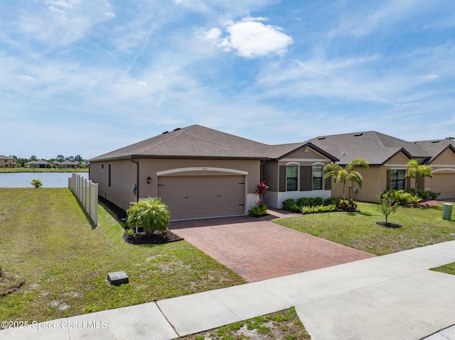 830 Remington Green Dr SE, Palm Bay, FL 32909 - single story home with an attached garage, decorative driveway, a front lawn, and a water view