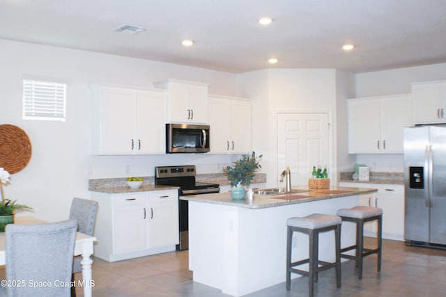830 Remington Green Dr SE, Palm Bay, FL 32909 - kitchen featuring a sink, white cabinetry, appliances with stainless steel finishes, and a center island with sink