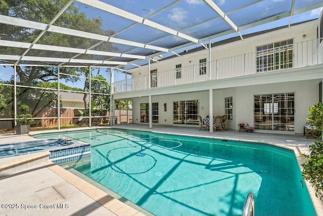 100 Woods S Dr, Merritt Island, FL 32952 - view of swimming pool featuring glass enclosure, a pool with connected hot tub, fence, and a patio area