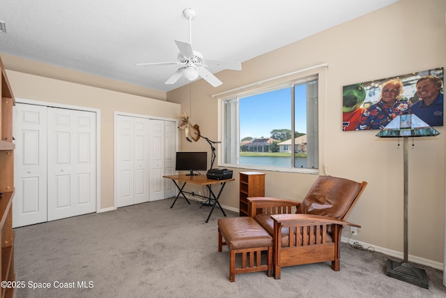 living area with carpet, ceiling fan, and baseboards