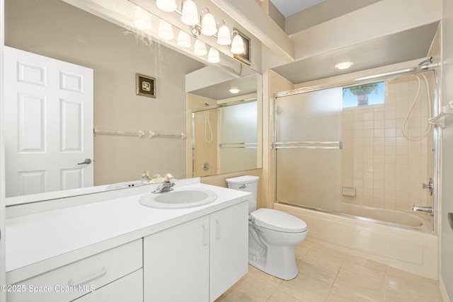 bathroom featuring tile patterned floors, vanity, toilet, and shower / bath combination with glass door