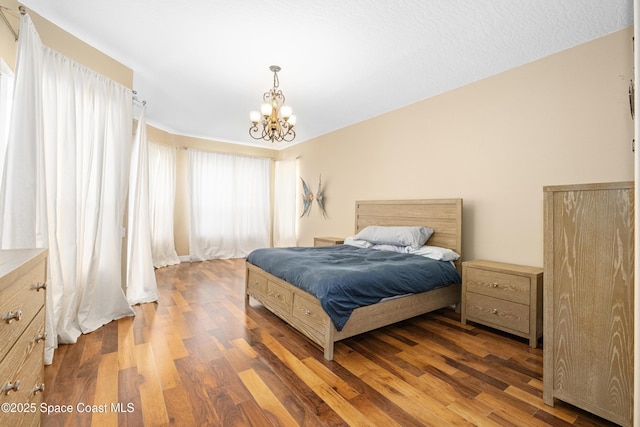 bedroom featuring wood finished floors and a chandelier