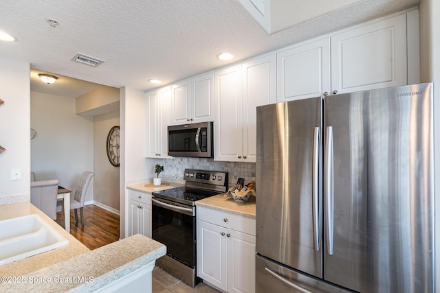 6838 Toland Dr Unit 307, Melbourne, FL 32940 - kitchen with stainless steel appliances, white cabinetry, light countertops, tasteful backsplash, and recessed lighting