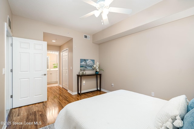 6838 Toland Dr Unit 307, Melbourne, FL 32940 - bedroom with wood finished floors, baseboards, connected bathroom, and ceiling fan