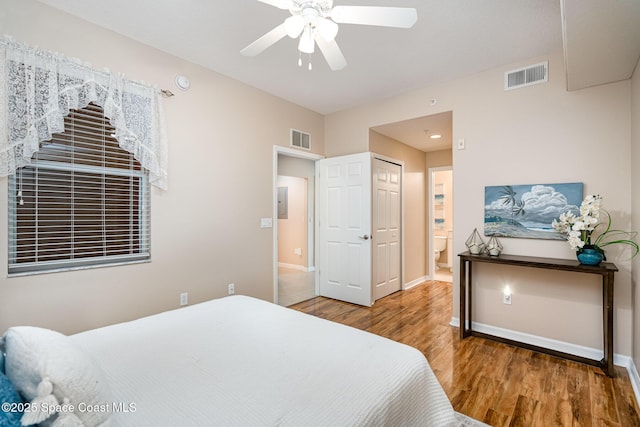 6838 Toland Dr Unit 307, Melbourne, FL 32940 - bedroom featuring wood finished floors, baseboards, ensuite bath, and a ceiling fan