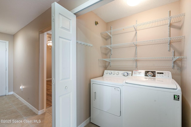 6838 Toland Dr Unit 307, Melbourne, FL 32940 - laundry room with washer and dryer, baseboards, and light tile patterned floors